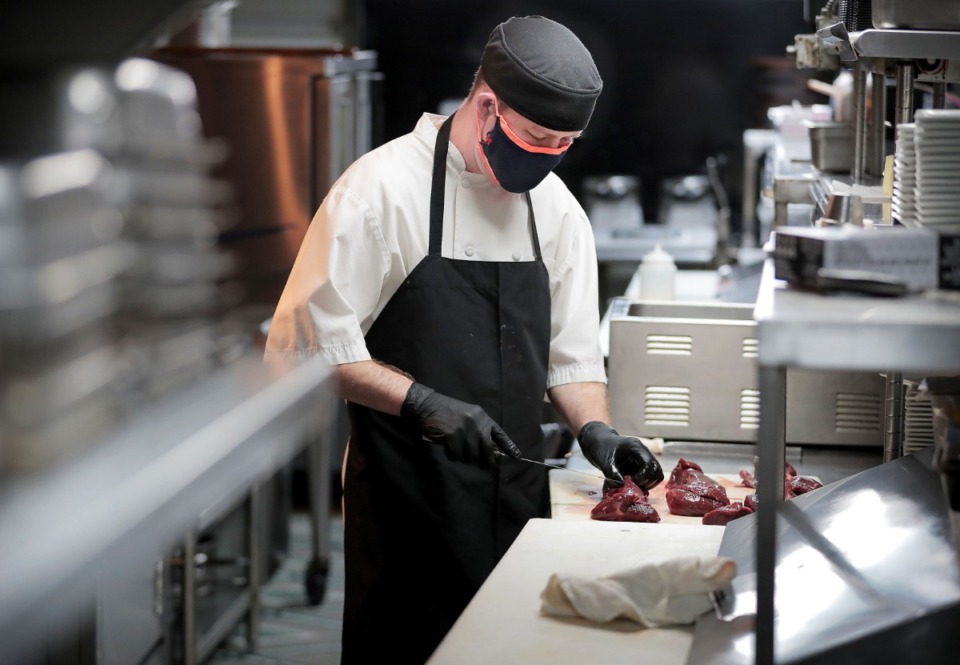 <strong>Flight chef Michael Boren carves elk tenderloin and does other prepwork for dinner takeout orders on April 24, 2020. The Downtown restaurant, which has had to reduce its usual Friday kitchen staff from 13 to 3, is one of the restaurants providing room service to Westin Beale Street guests during the coronavirus pandemic.</strong> (Jim Weber/Daily Memphian)