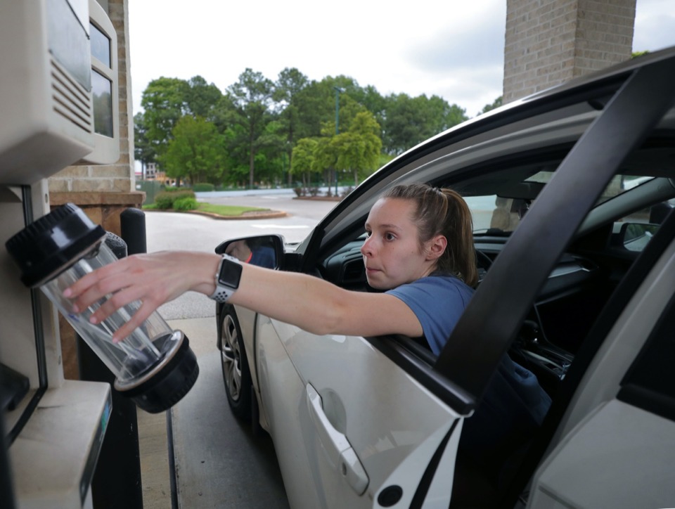 <strong>Wren Womack reaches to place a deposit in the pneumonic tube at Pinnacle Financial Partners' Poplar Avenue location April 28, 2020.</strong> (Patrick Lantrip/Daily Memphian)