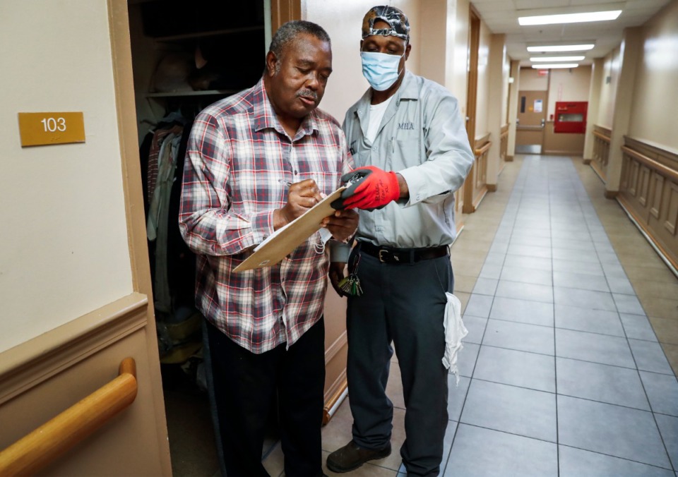 <strong>Memphis Housing Authority resident Joe Wilbourn (left) signs paperwork to receive donated face masks from Tedrick Robinson (right) on Thursday, April 23, 2020 at Dr. R.Q. Venson Center Apartment.</strong> (Mark Weber/Daily Memphian)