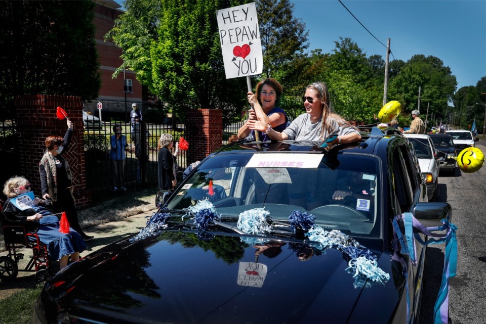 <strong>Cathy Bennett (top left) and daughter Camille Bennett (top right) wave to assisted living and skilled nursing residents from Trezevant Manor during a family parade on April 30, 2020. Residents from the Midtown retirement community have not seen family members since the facility went on lockdown due the COVID-19 outbreak.</strong> (Mark Weber/Daily Memphian)
