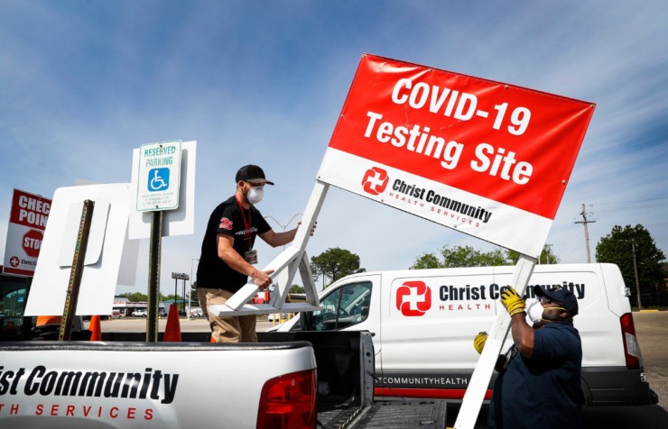<strong>Christ Community Health Services staff members Blake Chastain (left) and Derico Miller (right) setup a drive-thru COVID-19 testing site on Friday, April 17, 2020 in the Mendenhall Square Shopping Center. Christ Community will be opening virus testing sites in low-income area of Memphis starting this weekend.</strong> (Mark Weber/Daily Memphian)