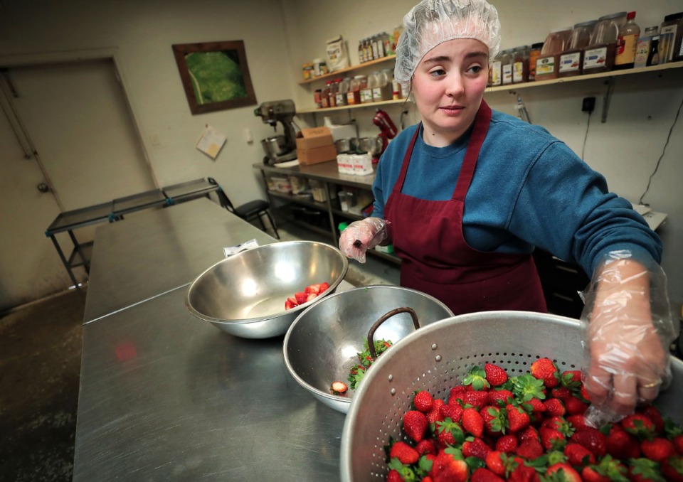 <strong>Emilie Barnes turns a box of Florida strawberries into jam on March 5 while getting ready for the spring berry season to kick in at Jones Orchard. The Millington orchard will be back at the Downtown Memphis Farmers Market when it reopens on Saturday, May 16.</strong> (Daily Memphian file)