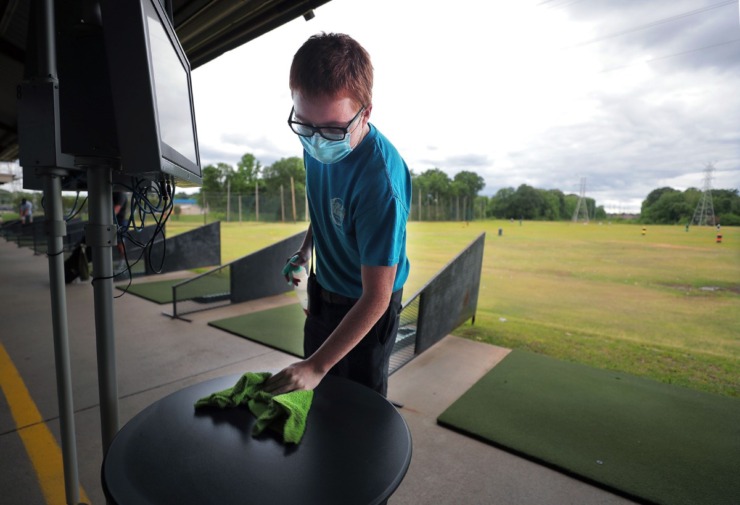 <strong>Jacob Bell wipes down the tables near the driving range between customers at Golf and Games Family Park May 19, 2020.</strong> (Patrick Lantrip/Daily Memphian)