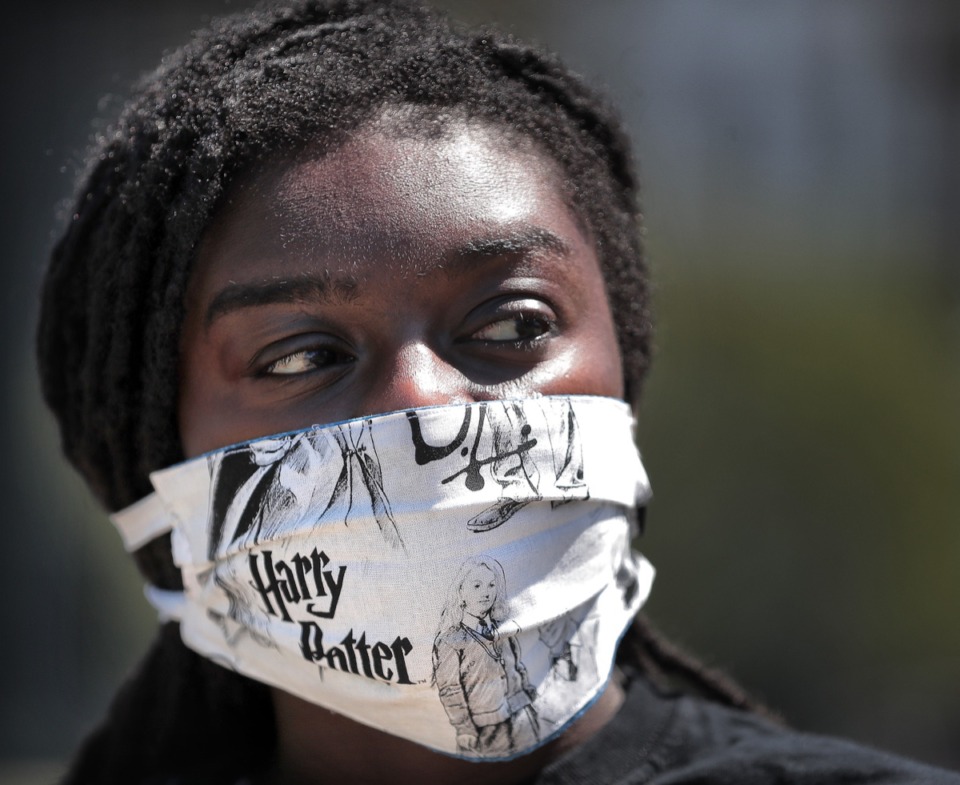 <strong>Diamond Sharpe sports her Harry Potter mask while walking along the bluff near Tom Lee Park in Downtown Memphis on May 1, 2020. Meanwhile, the debate rages on.</strong> (Jim Weber/Daily Memphian)