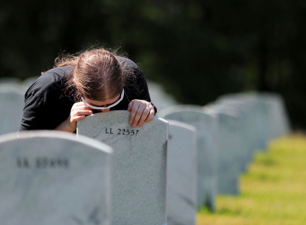 <strong>Heather McLean kisses the headstone of her friend's mother and Marine Corps veteran Dorothea "Dottie" Castillo at the West Tennessee State Veterans Cemetery on Memorial Day May 25, 2020</strong>. (Patrick Lantrip/Daily Memphian)