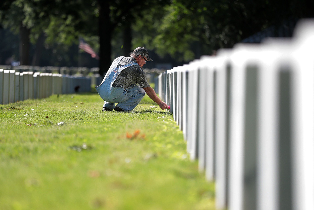 <strong>Alton Davis lays a single flower on the grave of his good friend, Marine sergeant Keith Wilson, at Memphis National Cemetery on Memorial Day May 25, 2020</strong>. (Patrick Lantrip/Daily Memphian)
