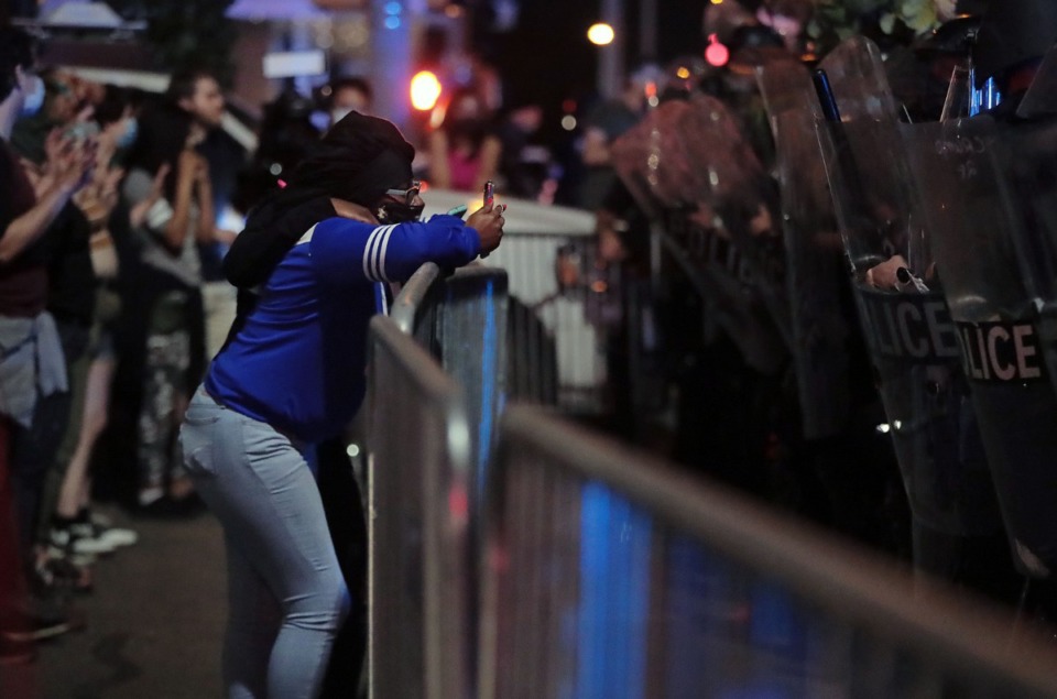 <strong>One protestor records a line of riot police during a May 28, 2020 protest over the death of George Floyd.</strong> (Patrick Lantrip/Daily Memphian)