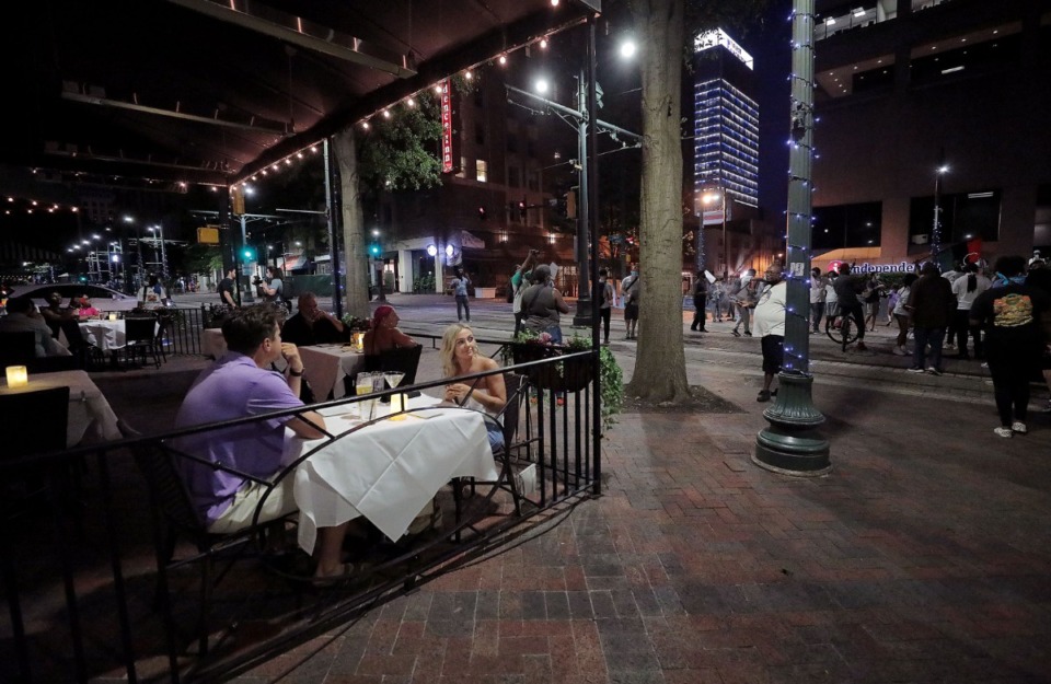 <strong>A couple eating diner is surprised to see several hundred protestors walk down Main Street during a May 29, 2020 march throughout Downtown Memphis to protest the murder of George Floyd by the Minneapolis Police.</strong> (Patrick Lantrip/Daily Memphian)