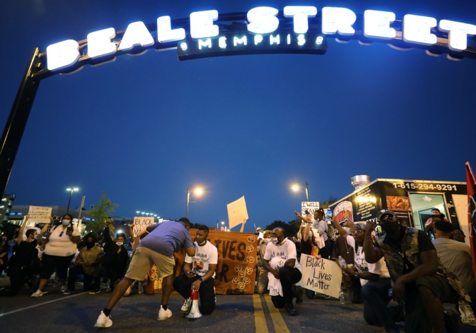 <strong>Protesters kneel under the Beale Street sign during the third night of protests over the murder of George Floyd.</strong> (Patrick Lantrip/Daily Memphian)