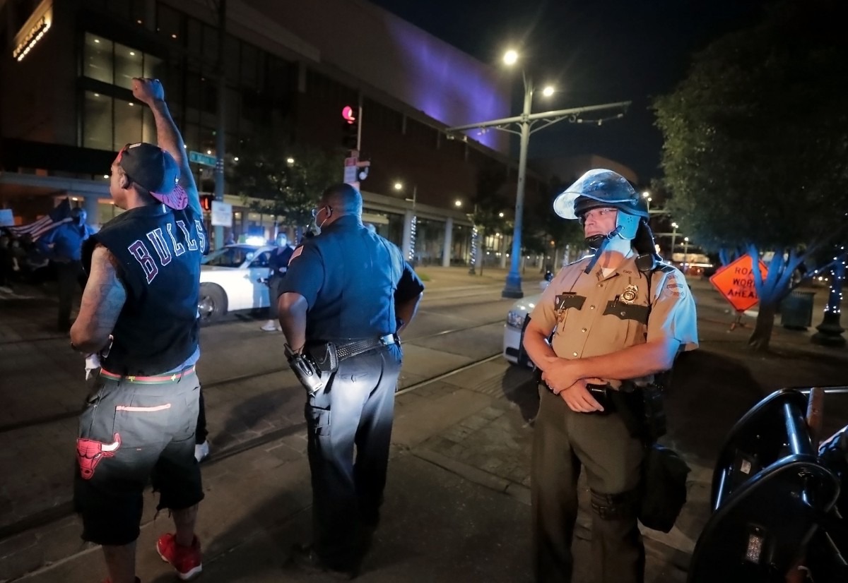 <strong>A protestor convinces a Tennessee State Trooper to put down his baton as the crowd peacefully passes down Poplar Avenue.</strong> (Patrick Lantrip/Daily Memphian)