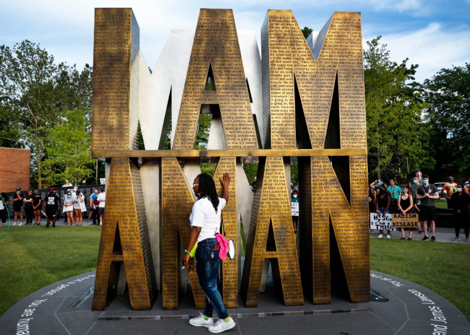 <strong>Protester Barbara Buress quietly touches the I AM A Man statue in Memphis on Monday, June 1, 2020, during a protest over the Minneapolis killing of George Floyd.</strong> (Mark Weber/Daily Memphian)