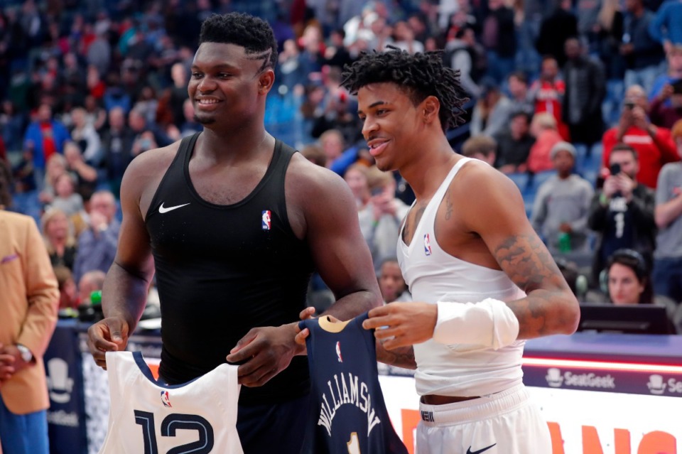 <strong>Memphis Grizzlies guard Ja Morant (right) and New Orleans Pelicans forward Zion Williamson exchange jerseys after a game in New Orleans on Jan. 31.&nbsp;The Grizzlies hold a 3.5-game lead for the No. 8 slot in the West over the Pelicans and Team Zion.</strong> (Gerald Herbert/Associated Press file)