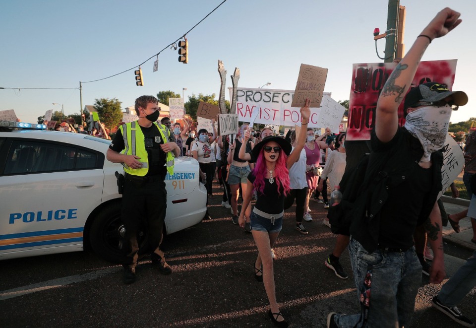 <strong>A Memphis Police officer watches group of protesters march through the intersection of Union Avenue and Cooper Street June 6, 2020 during the eleventh day of protesting over the death of George Floyd.</strong> (Patrick Lantrip/Daily Memphian)