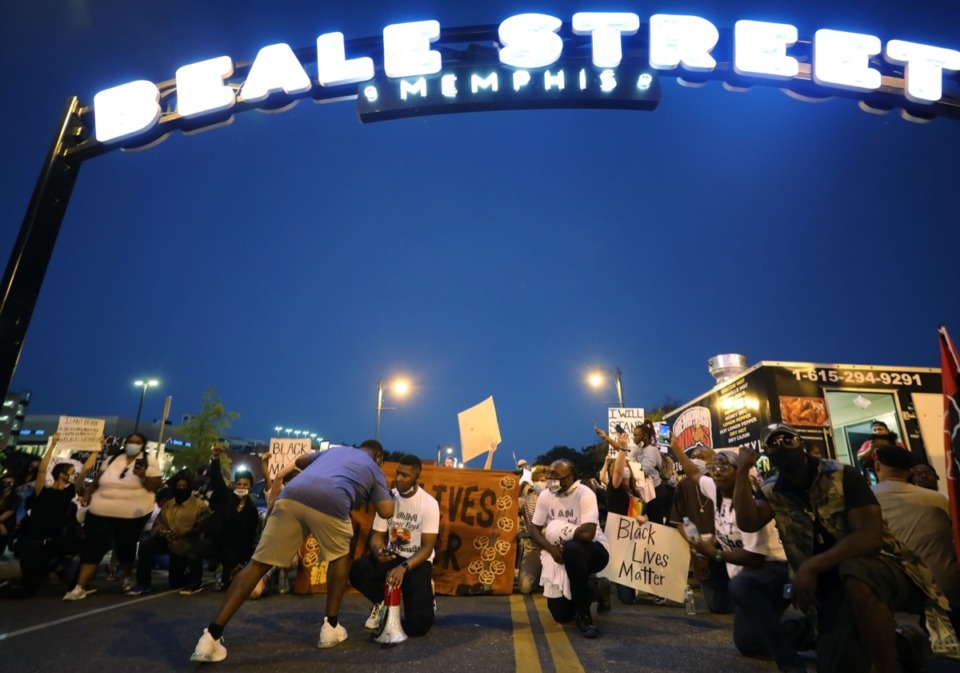 <strong>Protesters kneel under the Beale Street sign during the third night of protests over the murder of George Floyd, on May 29.</strong> (Patrick Lantrip/Daily Memphian)