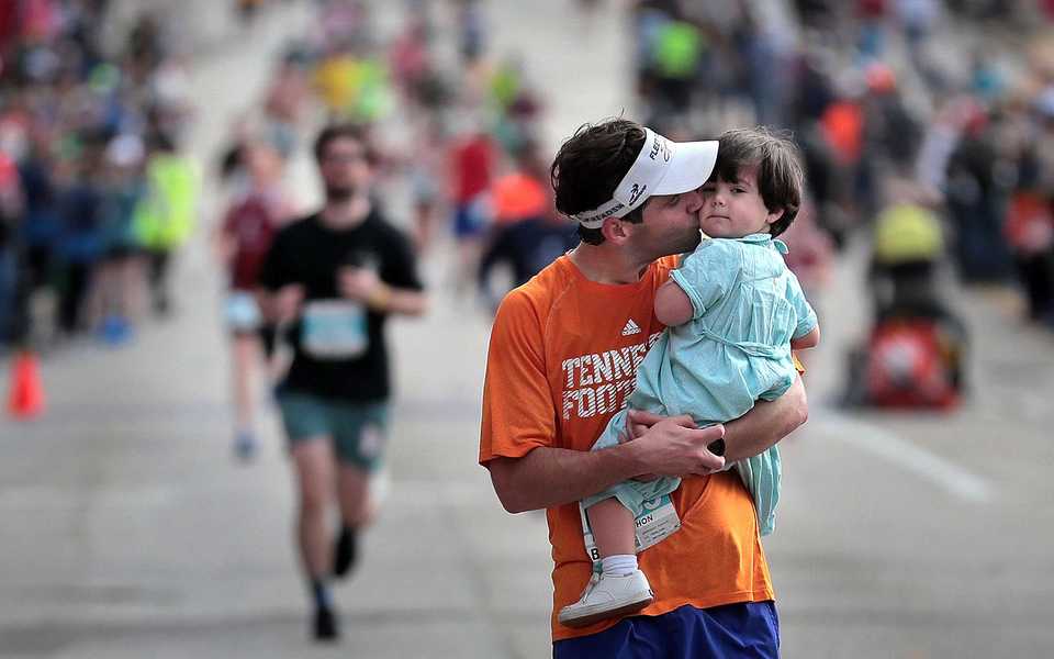 <strong>Michael Franks finishes the last few hundred yards of the half-marathon with his son Farris, 2, during the 17th annual St. Jude Memphis Marathon on Saturday Dec. 1, 2018. Despite two rain delays, over 26,000 runners participated in the charity event raising over $11 million for young cancer patients.</strong> (Jim Weber/Daily Memphian)