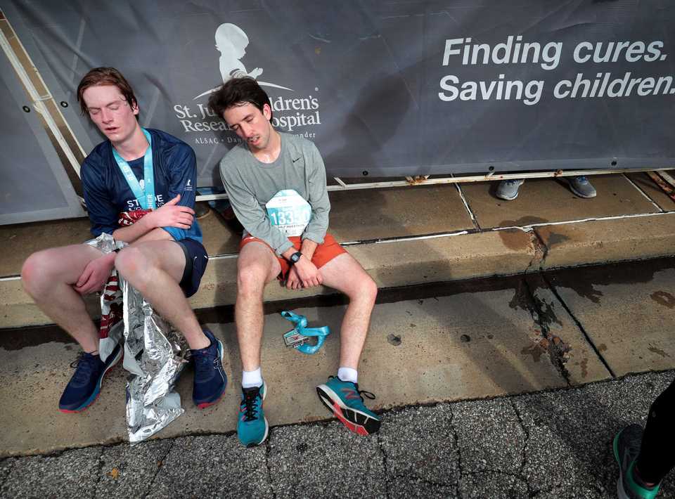 <strong>Runners take a rest before joining the crowd at Autozone Park during the 17th annual St. Jude Memphis Marathon on Saturday Dec. 1, 2018. Despite two rain delays, over 26,000 runners participated in the charity event raising over $11 million for young cancer patients.</strong> (Jim Weber/Daily Memphian)