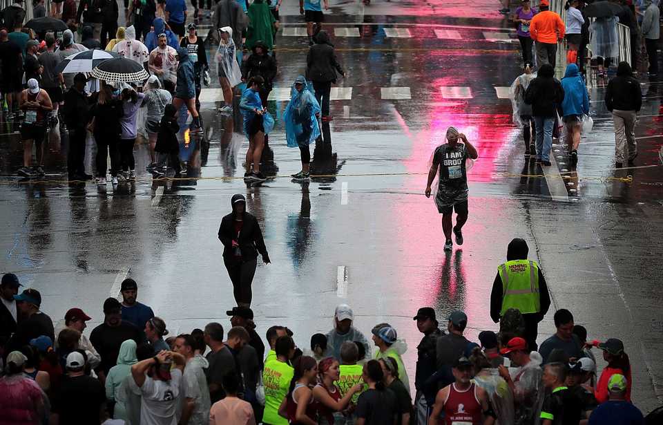<strong>Runners try to find some shelter from the rain before the start of the 17th annual St. Jude Memphis Marathon on Saturday Dec. 1, 2018. Despite two rain delays, over 26,000 runners participated in the charity event raising over $11 million for young cancer patients.</strong> (Jim Weber/Daily Memphian)