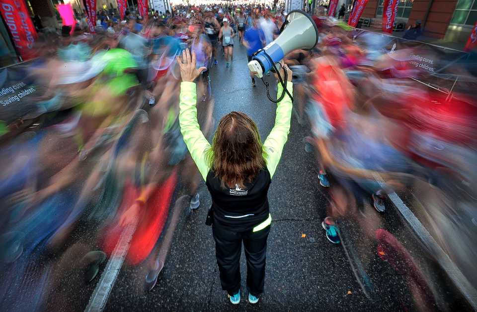 <strong>Barb McKeever directs runners around a camera stand at the start of the 17th annual St. Jude Memphis Marathon on Saturday Dec. 1, 2018. Despite two rain delays, over 26,000 runners participated in the charity event raising over $11 million for young cancer patients.</strong> (Jim Weber/Daily Memphian)