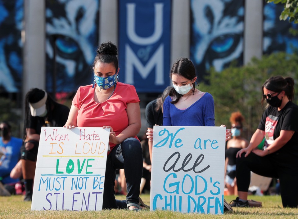 <strong>University of Memphis staff member Marta Lopez-Flohr (left) and her daughter, Gabriella Flohr, kneel in honor of George Floyd at a march on campus June 19, 2020.</strong> (Patrick Lantrip/Daily Memphian)