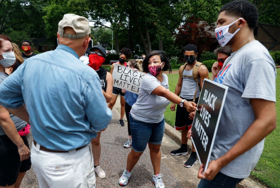 <strong>Memphis activist Theryn C. Bond (middle) tries to get Tim Treadwell (left) to say the words &ldquo;Black Lives Matter&rdquo; while pointing to a sign on Monday, June 29, 2020, during a protesting outside of the home of Lloyd Crawford in Germantown. The group was protesting Crawford, who confronted a demonstrator carrying a "Black Lives Matter" sign on Saturday.</strong> (Mark Weber/Daily Memphian)