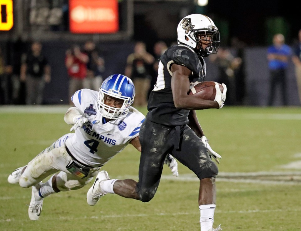 <strong>Memphis defensive back Josh Perry (4) attempts to stop Central Florida running back Greg McCrae (right) during an NCAA college football game in December in Orlando.</strong> (John Raoux/Associated Press file)