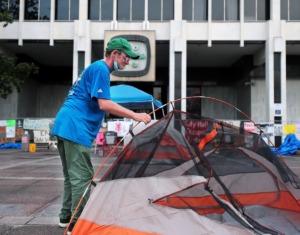 <strong>A man sets up a tent in front of Memphis City Hall June 30, 2020. What started out as a Black Lives Matter protest has evolved into a campaign to feed and provide shelter to Downtown's homeless population.</strong> (Patrick Lantrip/Daily Memphian)