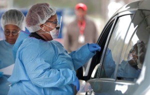 <strong>Medical Assistant Jasmine King swabs a drive-thru patient as staff from Christ Community Health Services administer some 50 free COVID-19 tests at a tent behind their South Memphis clinic on March 21, 2020. </strong>(Jim Weber/Daily Memphian file)