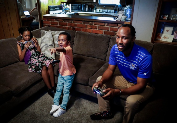 <strong>Develle Duckett (right) plays video games with his son Dallas, 3, (middle) as daughter Kendyll, 10, (left) watches a videos on her smartphone on Wednesday, July 15, 2020. Parents, like the Ducketts say it has been rough trying to work from home while keeping their child occupied with no summer camp, no dance classes, no arts programs, no sports or swim classes due to the pandemic.</strong> (Mark Weber/Daily Memphian)