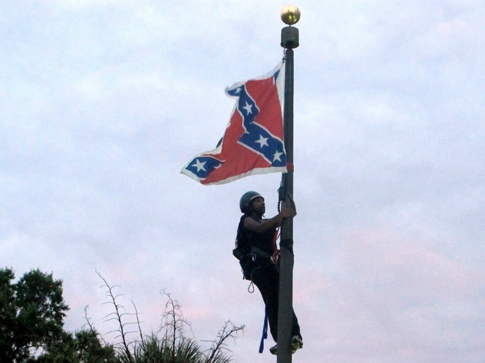 <strong>In this June, 27, 2015, file photo, Bree Newsome of Charlotte, N.C., climbs a flagpole to remove the Confederate battle flag at a Confederate monument in front of the Statehouse in Columbia, S.C. After nine black parishioners were slain at a Charleston church, South Carolina did what many thought would never happen: It moved the Confederate flag off Statehouse grounds.</strong> (Bruce Smith, AP File)