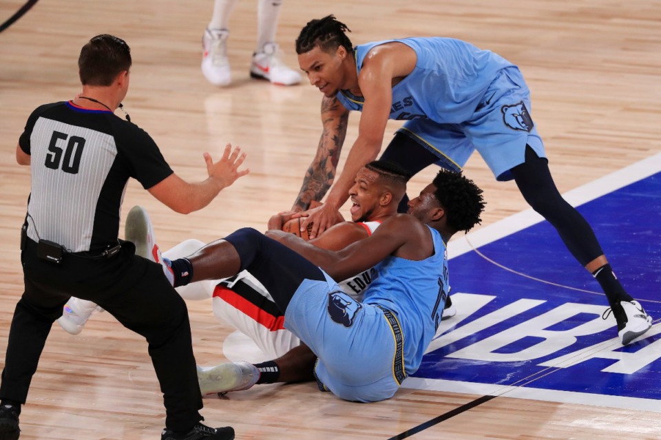 <strong>Memphis Grizzlies&rsquo; Jaren Jackson Jr. (13) and Portland Trail Blazers CJ McCollum (3) compete for a loose ball during the second half of an NBA game Friday, July 31, in Orlando. The Grizzlies lost in overtime, 140-135.</strong> (Mike Ehrmann/Associated Press)