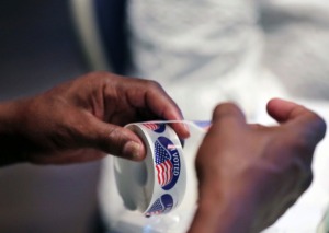 <strong>A poll worker tears off an "I voted" sticker at Faith Presbyterian Church in Germantown during the primary election Aug. 6, 2020.</strong> (Patrick Lantrip/Daily Memphian)