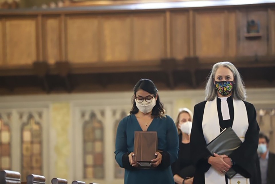 <strong>Sumita Montgomery carries her father&rsquo;s ashes alongside the Rev. Anne H.K. Apple at Steve Montgomery&rsquo;s funeral service on Friday, Aug. 7.</strong> (Courtesy of&nbsp;Craig Thompson)