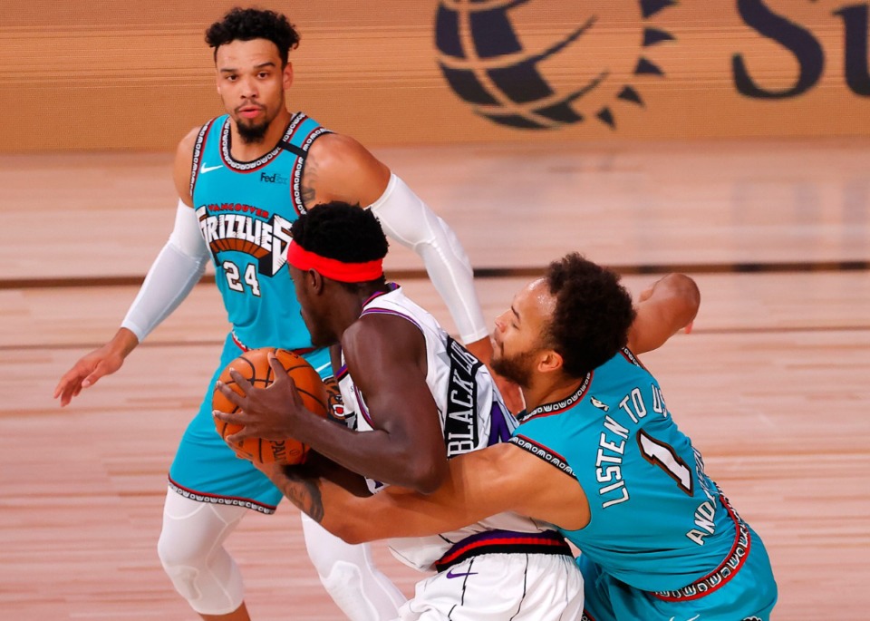 <strong>Memphis Grizzlies' Kyle Anderson (1) reaches for a steal against Toronto Raptors' Pascal Siakam, center, as Grizzlies' Dillon Brooks (24) watches during the first quarter of an NBA basketball game Sunday, Aug. 9, 2020, in Lake Buena Vista, Fla.</strong> (Kevin C. Cox/AP)