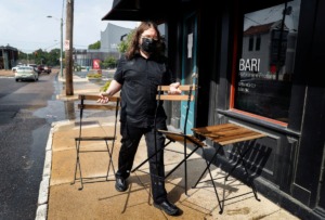 <strong>Bari Ristorante e Enoteca waiter Brandon Noe sets up outdoor seating on Tuesday, Aug. 11. The Midtown restaurant has asked for street seating, an allowance city administrators announced they would consider on a case-by-case basis.</strong> (Mark Weber/Daily Memphian)