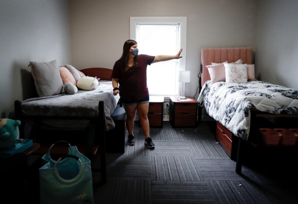<strong>Christian Brothers University soon-to-be freshman Emma Clark points where she&rsquo;ll watch movies using a projector placed on an extra bed in her dorm room during move-in day on Tuesday, August 11, 2020. The dorms at CBU will be housing students at half capacity, leaving most dorm residents with a room to themselves due to restrictions cause by the COVID-19 pandemic.</strong> (Mark Weber/Daily Memphian)