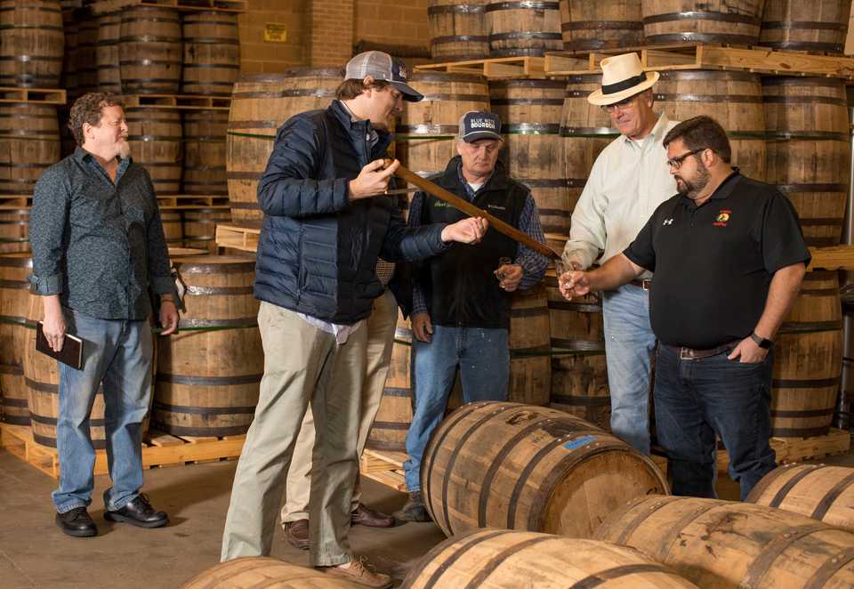<strong>Blue Note Bourbon owner McCauley Williams pours bourbon from a copper thief to (from right) Trimm, Blondis and Sweet Grass bartender Harold Cook.</strong> (Photo by Justin Fox Burks, courtesy of Sweet Grass)