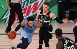 <strong>Memphis Grizzlies guard Dillon Brooks (24) drives against Milwaukee Bucks guard Donte DiVincenzo (top right) in their game Thursday, Aug. 13, in Lake Buena Vista, Fla. The Grizzlies won 119-106, and are headed to the NBA&rsquo;s first Western Conference playoff play-in.</strong> (Kim Klement/Associated Press)
