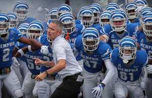 <strong>University of Memphis coach Mike Norvell (center) leads his team onto the field against UCF at Liberty Bowl Memorial Stadium on Oct. 13, 2018. Amid speculation he might be interested in other coaching jobs, Norvell said Monday he intends to stay with the Tigers program.</strong> (Jim Weber/Daily Memphian file)