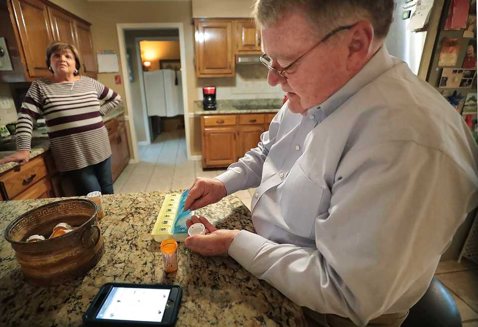 <strong>Lung cancer patient Dan Merrill uses the Baptist OneCare MyChart app to help keep track of medications as he stocks up his pill counter Nov. 30, 2018, at his home in Bartlett. Baptist Memorial Health Care is one of six institutions sharing a $9 million grant to pilot an app specifically designed to help cancer patients report symptoms to their physicians.&nbsp;</strong>(Jim Weber/Daily Memphian)