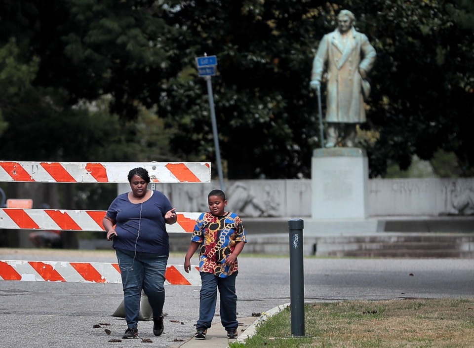 <strong>Tammie Echols and her son Torrence Echols, 8, walk past the barricaded entrance to Overton Park on April 4, as Memphians practice social distancing during workouts, dog walks and bike rides.</strong> (Jim Weber/Daily Memphian file)