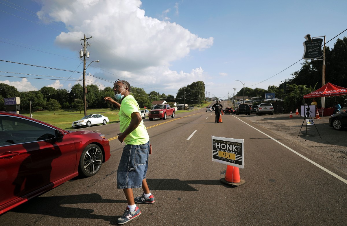 <strong>Keith King encourages passing cars to honk their horn to celebrate Dr. Charles Champion's 90th birthday Saturday, Aug. 22.</strong> (Patrick Lantrip/Daily Memphian)