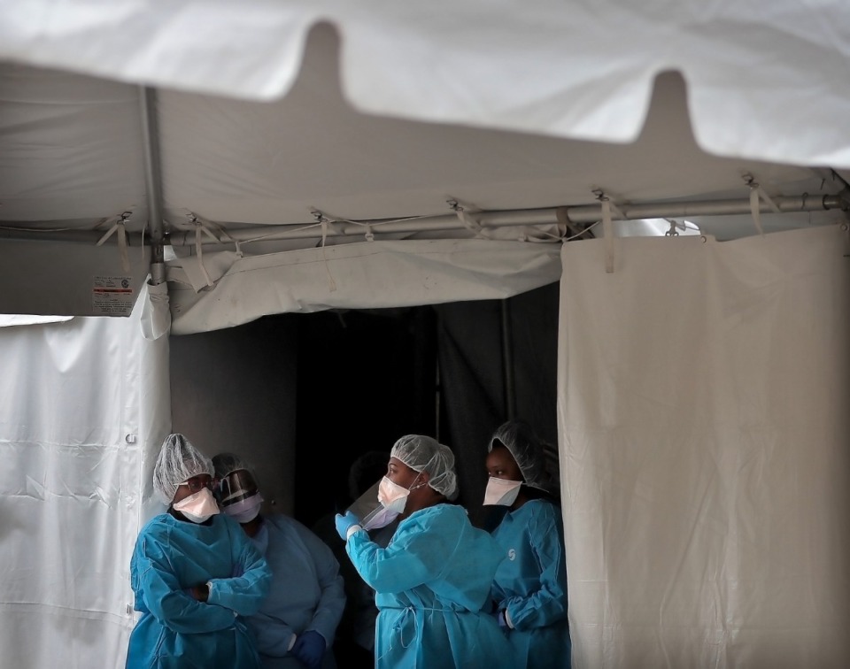 <strong>Health care workers wait for the next drive-thru patient as staff from Christ Community Health Services administer COVID-19 tests at a tent behind its South Memphis clinic on March 21, 2020.</strong> (Jim Weber/Daily Memphian)