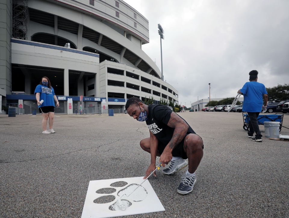 <strong>B.J. Ross paints a tiger paw on the group to help people stay six feet apart when waiting in line to get into the Liberty Bowl Sept. 3, 2020.</strong> (Patrick Lantrip/Daily Memphian)