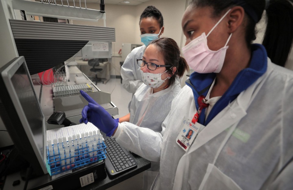 <strong>Medical technicians Jasmine Becton (right), Lanthanh Nguyen and Calisha Beauregard log and test patient samples collected from Tiger Lane at UTHSC's Coronavirus testing lab in the Hamilton Eye Center on April 16, 2020.</strong>&nbsp;(Daily Memphian file)
