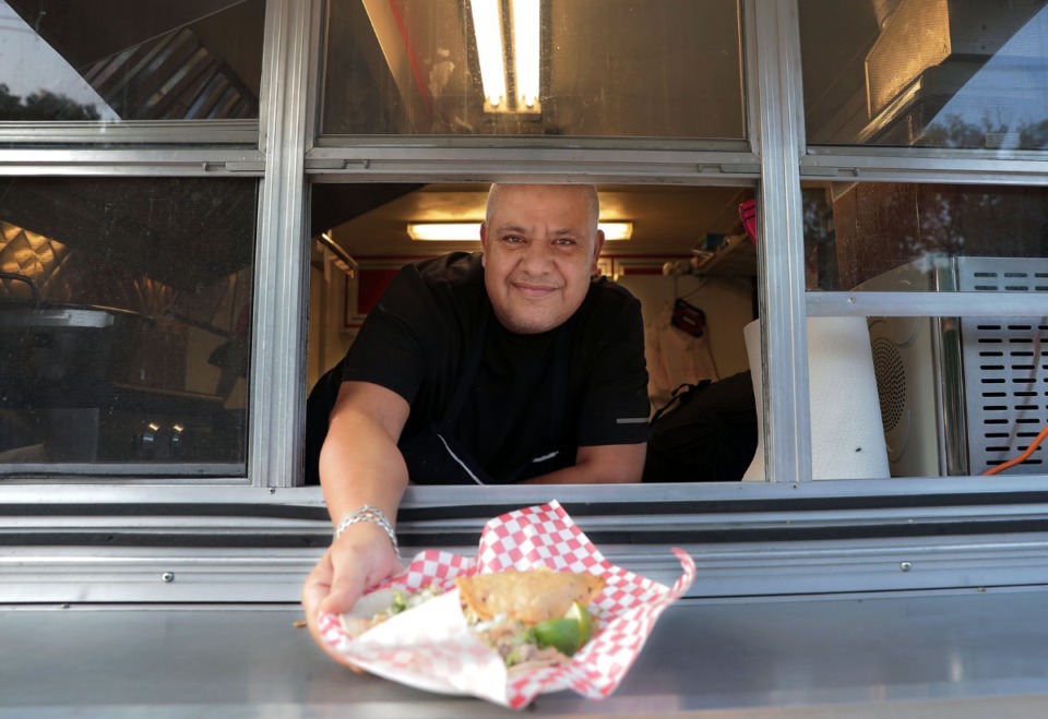 <strong>Jose Garcia hands out a plate of pork tacos from the window of his Carnitas Gri's food truck.&nbsp;</strong>(Patrick Lantrip/Daily Memphian)