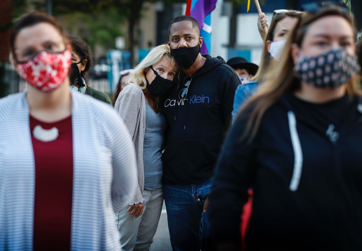 <strong>Kate Zane (back left) embraces her husband John Russell (back right) while attending a memorial for the late Supreme Court Associate Justice Ruth Bader Ginsburg Sept. 21 at the Judge D&rsquo;Army Bailey Courthouse.</strong> (Mark Weber/The Daily Memphian)