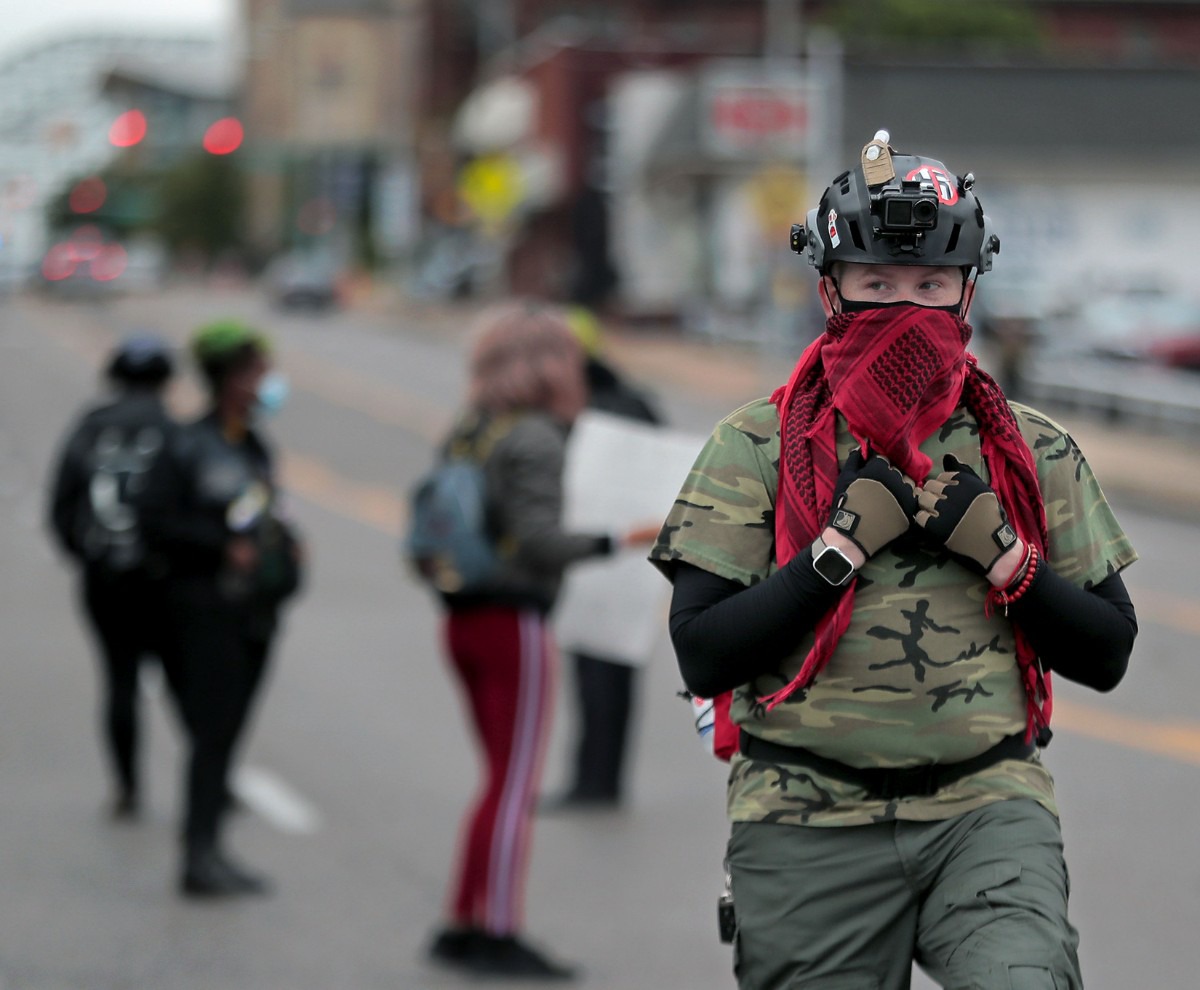 <strong>A protest marshal keeps an eye on the crowd while demonstrators block Poplar Avenue Downtown on Sept. 24.</strong> (Patrick Lantrip/Daily Memphian)