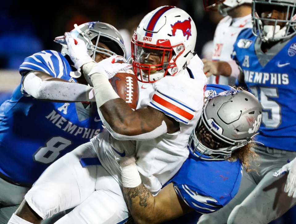 <strong>Memphis defenders Xavier "Zay" Cullens (left) and Jonathan Wilson (right) tackle SMU running back Ke'Mon Freeman (middle) during their 2019 game at the Liberty Bowl Memorial Stadium.</strong> (Mark Weber/Daily Memphian file)