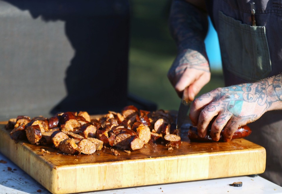 <strong>Brent McAfee prepares sausage during a Restaurant Phoenix Project dinner. The program benefits local restaurants, or in the case of the event held on a farm in Williston, Tennessee Oct. 3, 2020, to benefit a farmer.</strong> (Patrick Lantrip/Daily Memphian)