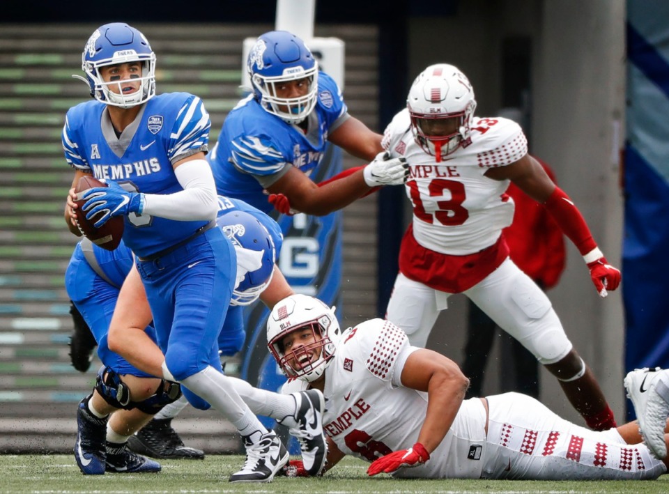<strong>Memphis quarterback Brady White (left) scrabbles out of the grasp of Temple defender Daniel Archibong (bottom right) during action on Saturday, Oct. 24, 2020 at Liberty Bowl Memorial Stadium.</strong> (Mark Weber/The Daily Memphian)